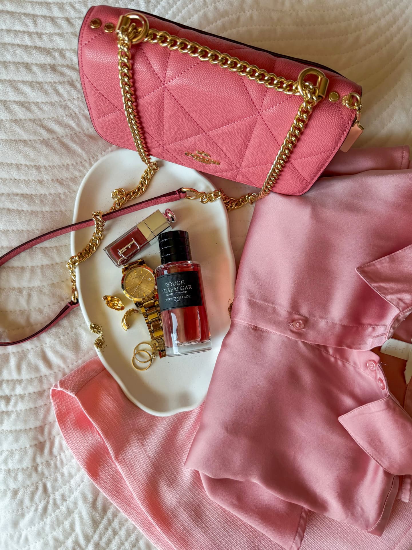 Růžové flatlay s kabelkou a parfémem